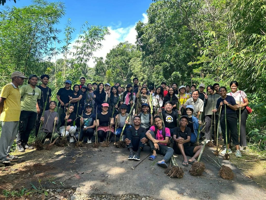 A large group of Voluntrip volunteers posing in a forest clearing.